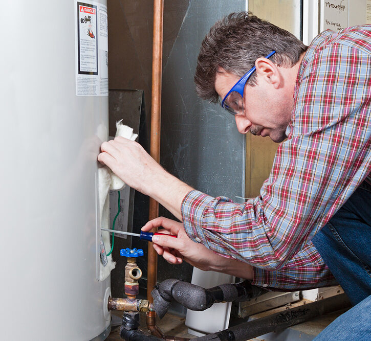 A plumber is performing maintenance on a residential water heater